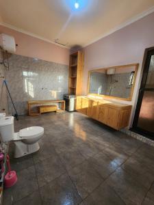 a bathroom with a toilet and a sink and a tub at Hakuna Matata House in Arusha