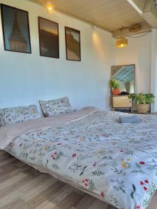 a bedroom with a large bed with a floral bedspread at Cuc ku homestay in Ấp Ða Lợi