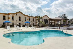 una piscina con sedie e un edificio di Quality Inn Surfside Myrtle Beach a Myrtle Beach