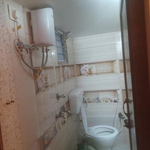 Un baño con un inodoro blanco en una habitación. en Hotel Sunset Park, en Calcuta