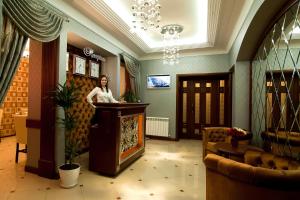 a woman standing at a podium in a lobby at Villa Rossa Hotel in Chişinău