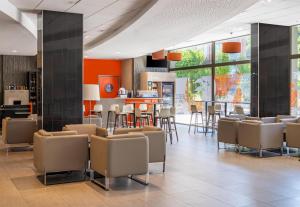 a lobby with chairs and a bar in a building at Spark by Hilton Lyon Park Saone in Lyon