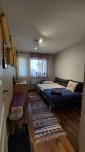 a bedroom with two beds and a rug at Комната в квартире, 20 минут от центра Осло на общественном транспорте in Grorud