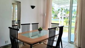 a dining room with a glass table and chairs at Maison Lakazbleu - 100m plage Mont Choisy in Mont Choisy