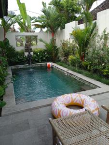a small swimming pool with a float in a garden at Villa Brahmari in Ubud