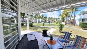 a porch with chairs and a table and a patio at Maison Lakazbleu - 100m plage Mont Choisy in Mont Choisy