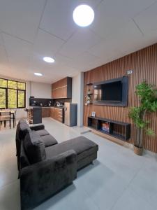 Una sala de estar con un sofá y un televisor de pantalla plana. en Ikitu House, en Iquitos