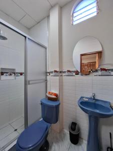 Un baño con un inodoro azul y un lavabo. en Ikitu House, en Iquitos