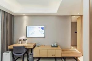 景洪にあるLavande Hotel·Xishuangbanna Jinghong Songkran Squareのデスク、椅子、モニターが備わる客室です。
