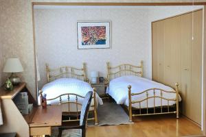 a bedroom with two beds and a desk and a desk at Asahikawa - house / Vacation STAY 5789 in Higashikagura