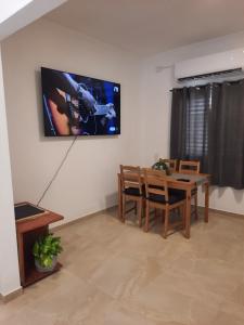 a living room with a table and a tv on the wall at דירת הנחל in Metsudat Menahem Ussishkin Alef +2 photos