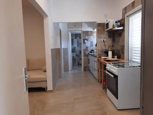 a small kitchen with a stove and a couch at דירת הנחל in Dafna