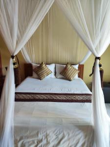 una camera da letto con un letto a baldacchino di Dalum Homestay ad Amed