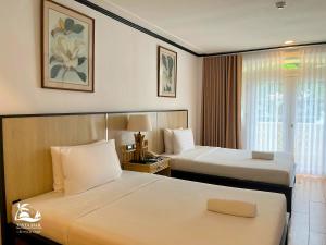 a hotel room with two beds and a window at Vista Mar Beach Resort and Country Club in Mactan +58 photos