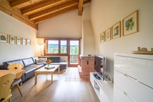 a living room with a couch and a tv at Edelweiss Ferienwohnung, Attica Muntognas in Flims +29 photos