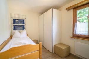 a small bedroom with a bed and a window at Edelweiss Ferienwohnung, Attica Muntognas in Flims