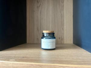a jar of jam sitting on a wooden shelf at TRINAVIS Boutique Apartments, OWN PRIVATE PARKING, City Center, Entire Apartment in Veliko Tŭrnovo