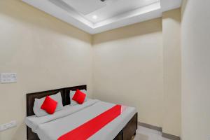 a bedroom with a bed with red pillows on it at Hotel O Mt Stays in Noida