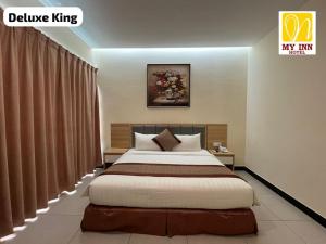 a bedroom with a large bed in a room at My Inn Hotel Inanam in Inanam +8 photos