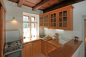 a kitchen with wooden cabinets and a counter top at Sörényes Udvarház in Pénzesgyőr