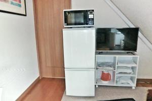a microwave sitting on top of a refrigerator at Asahikawa - House - Vacation STAY 78092v in Asahikawa