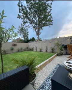 a backyard with a fence and a lawn at Olive Tree Cottage in Golcar