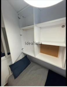 een kleine kamer met witte planken en een blauw kussen bij Casa Duque in Madrid