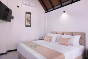 a bedroom with a large white bed with pillows at Mr & Mrs K's Villa- Kandy in Kandy