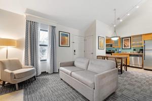 a living room with a couch and a table at MainStay Suites St Louis - Galleria in Richmond Heights