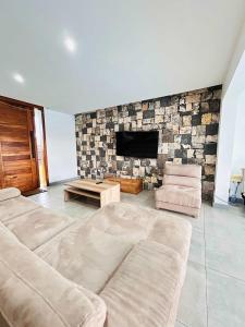 a living room with a couch and a stone wall at Luxurious 3 Bedroom Villa with Private Pool - NG1 in Arsenal