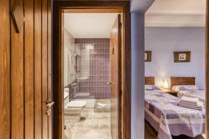 a bathroom with a shower and a bedroom with two beds at Casa Rural El Torn in Garriguella +30 photos
