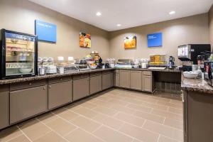 a large kitchen with a counter top with food at Comfort Suites in Humble