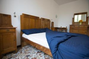 LongareにあるLa Casa dei Lumiのベッドルーム1室(木製ヘッドボード付きのベッド1台付)