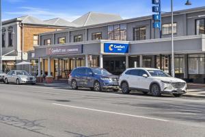 a group of cars parked in front of a building at Comfort Inn Commodore Albury in Albury