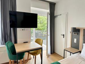 リュッセルスハイムにあるDORMERO Hotel Rüsselsheim Airport-Frankfurtのデスクとベッドルームが備わるホテルルームです。