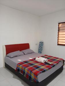 a bedroom with a bed with a plaid blanket at ibilik Changloon in Changlun +3 photos