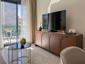 a living room with a television on a cabinet at Qoople Legend B - premium apartments steps from the sea in Alanya