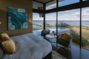 a bedroom with a bed and a view of the ocean at Little Beach Resort in Four Mile Creek