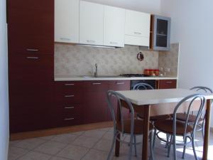 GasponiにあるResidenza Giscorの白いキャビネット、テーブルと椅子付きのキッチンが備わります。