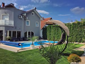 a house with a swimming pool in front of a house at Vila DeLux in Negotin