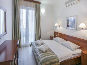 a bedroom with a bed and a desk and a window at Apartment in Veli Losinj by the Sea in Veli Lošinj