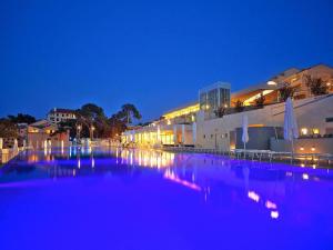 a large swimming pool at night with a building at Apartment in Veli Losinj by the Beach in Veli Lošinj +29 photos