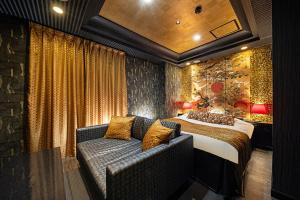 een hotelkamer met een bed en een bank bij HOTEL FIVE plus -Adult Only- in Osaka