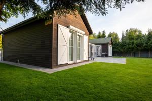 una casa con porte bianche e un prato di Wypocznij na Wspólnej 