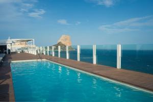 
a beach with a pool and a pier at Hotel Bahía Calpe by Pierre & Vacances in Calpe
