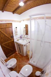 a bathroom with two toilets and a shower and a sink at Casa da Rainha in Calheta