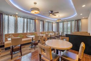 a restaurant with tables and chairs and windows at Comfort Inn Anaheim Resort in Anaheim