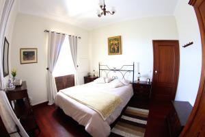 a bedroom with a bed and a window at Casa da Rainha in Calheta