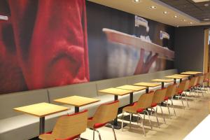 uma fila de mesas e cadeiras numa sala de aula em ibis Chapeco em Chapecó