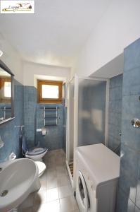 a bathroom with a toilet sink and a washing machine at Antico Casale il Dopolavoro in Valdidentro